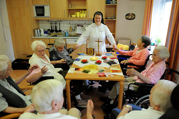 alte Damen im Gebetskreis mit einer Ordensschwester