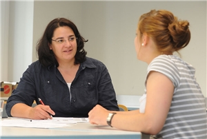 Eine junge Frau wird von einer Mitarbeiterin der Caritas beraten