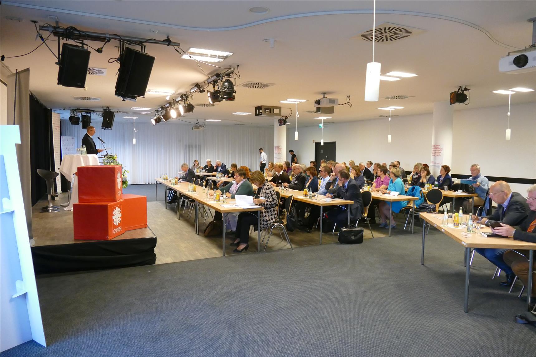 Blick in Saal mit Tisch- und Stuhlreihen