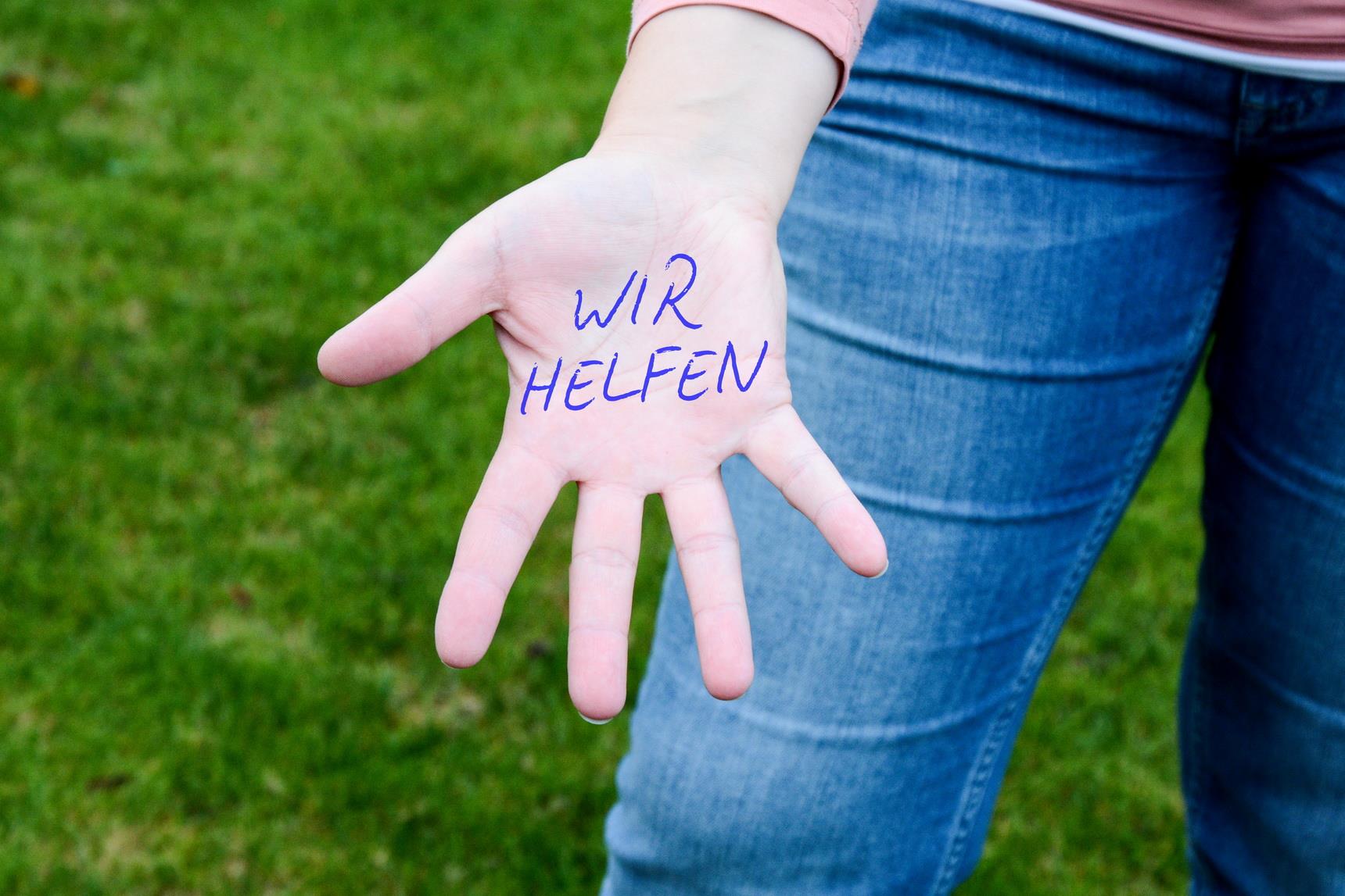 Ausgestreckte Hand mit Aufschrift Wir helfen