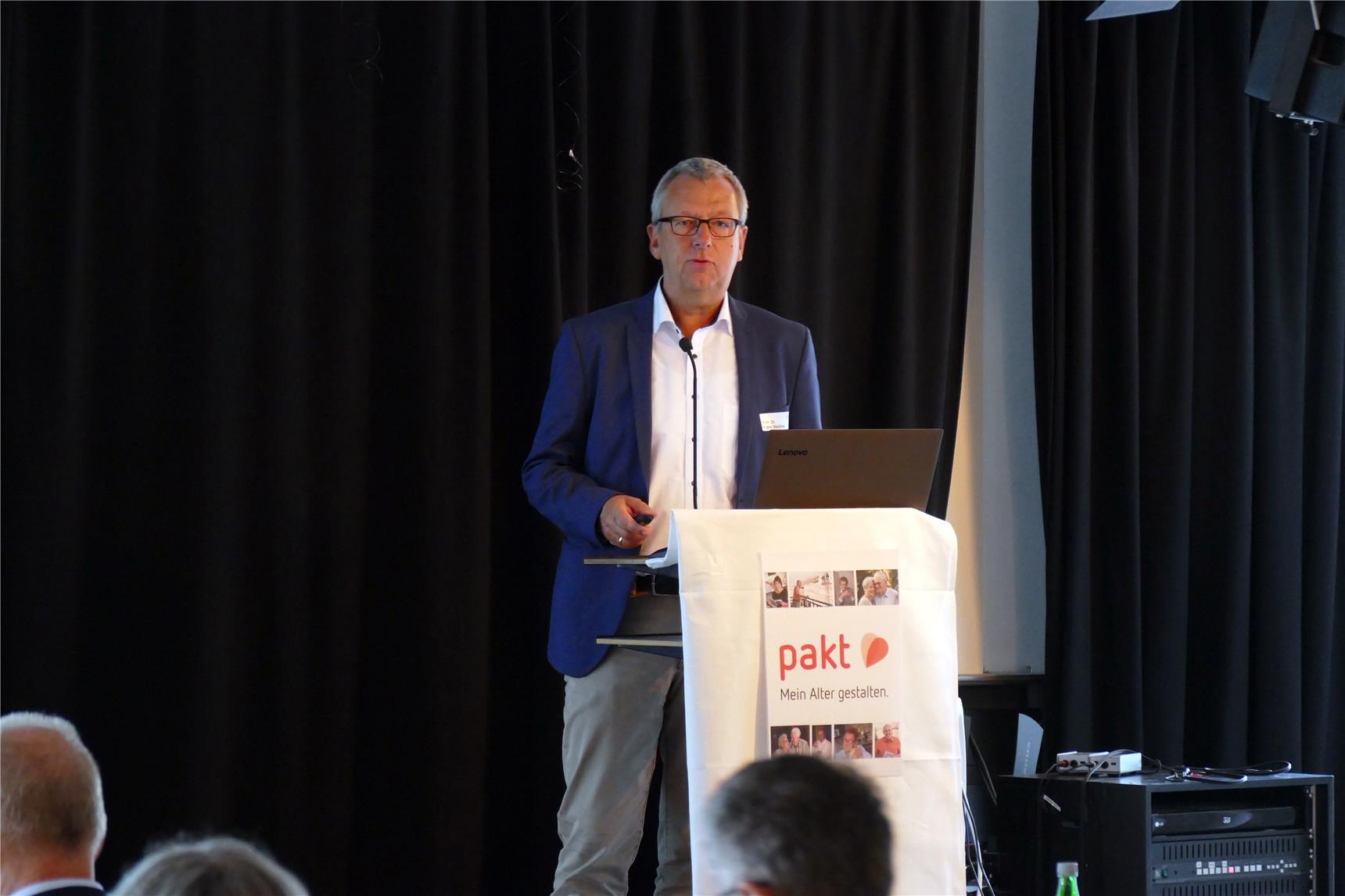 Redner am Rednerpult vor schwarzem Hintergrund