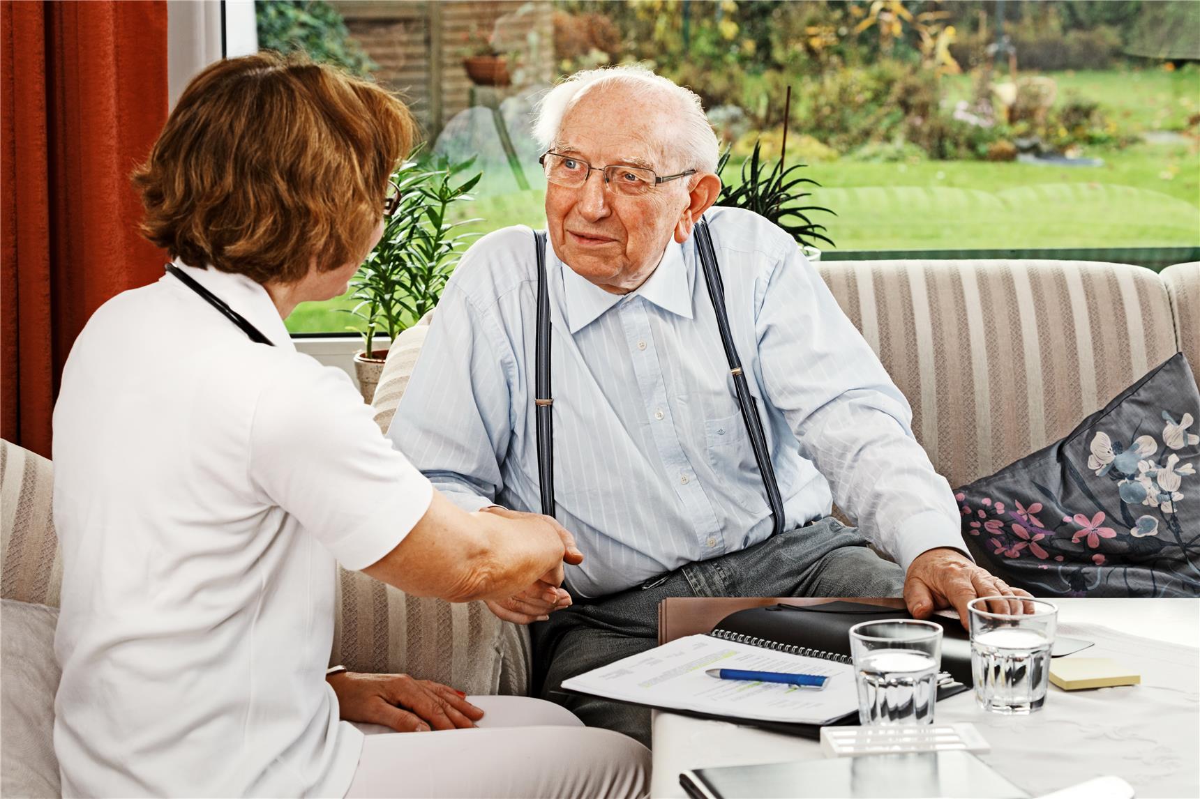 Pflegerin berät zu pflegenden Mann