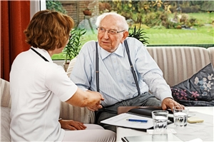 Pflegerin berät zu pflegenden Mann