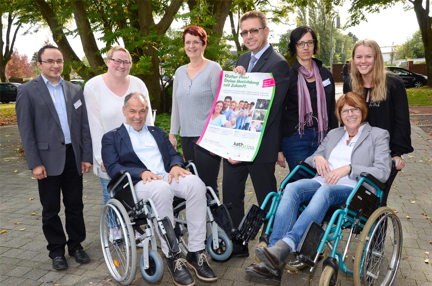 Menschengruppe, einige sitzen in Rollstühlen