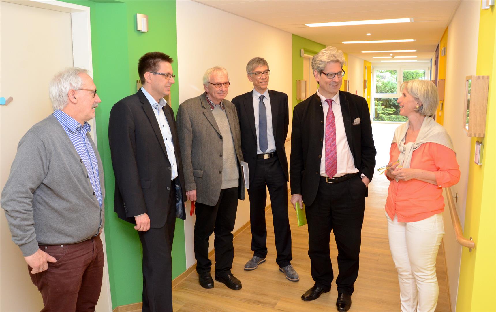 Gruppe steht im Halbkreis im Flur eines Altenheimes