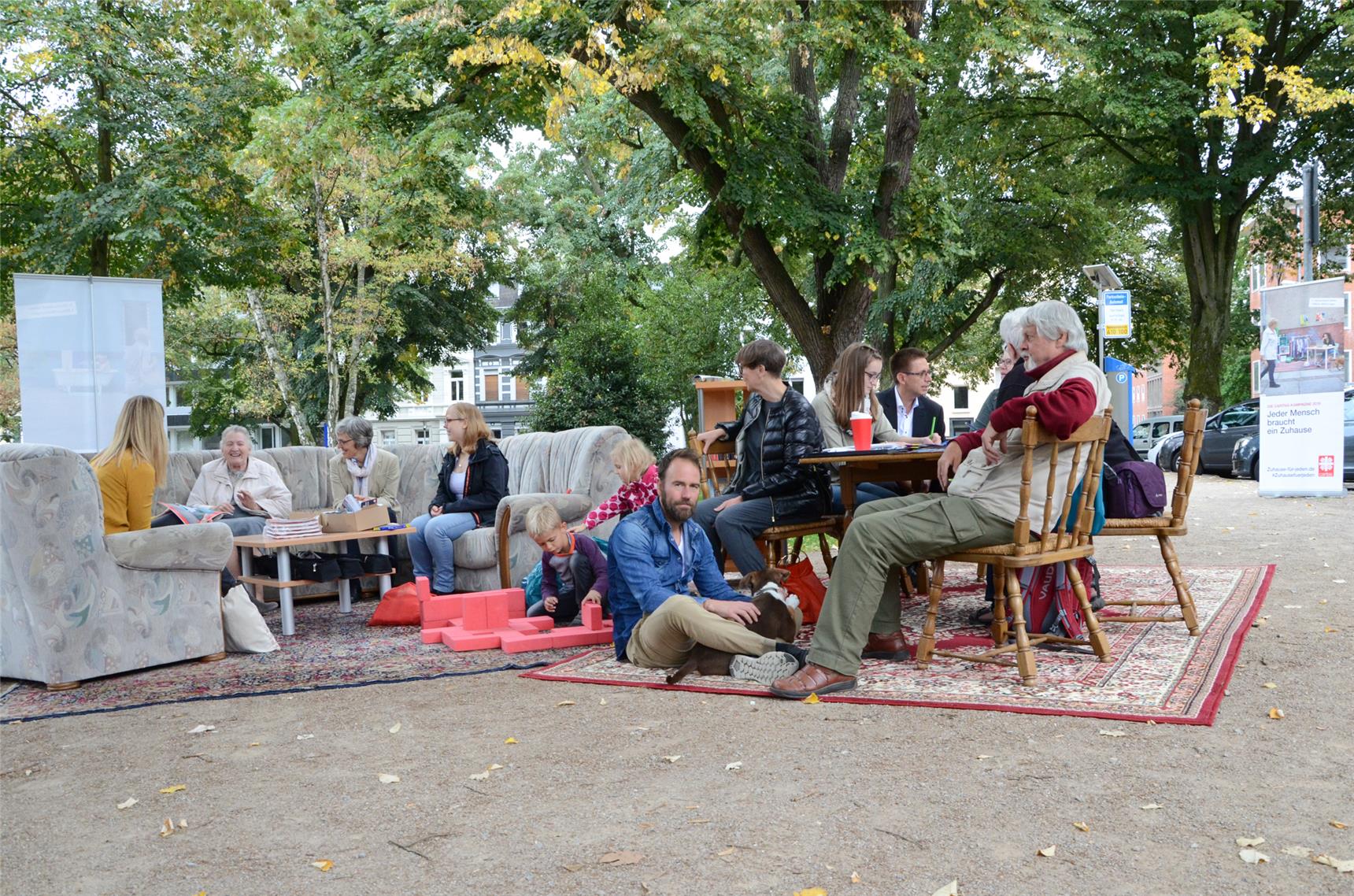 Menschen sitzen unter freiem Himmel auf Couch- und Sitzgarnitur.