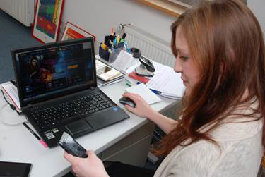 Susanne Schulte, zuständig für Projekt 2.0 Exit, sitzt an ihrem Arbeitsplatz und blickt auf ihr Smartphone