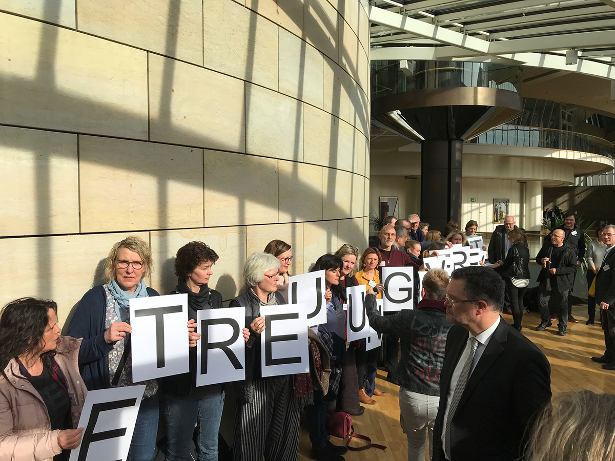 Vertreterinnen und Vertreter der Freien Wohlfahrtspflege stehen im Landtag und bilden vor den Mitgliedern des Rechtsauschusses mit Papierschildern das Wort 'Betreuungsrecht'.