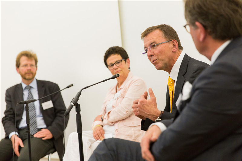 Die Referenten des Akademietags sitzen in der Dialogrunde auf dem Podium zusammen