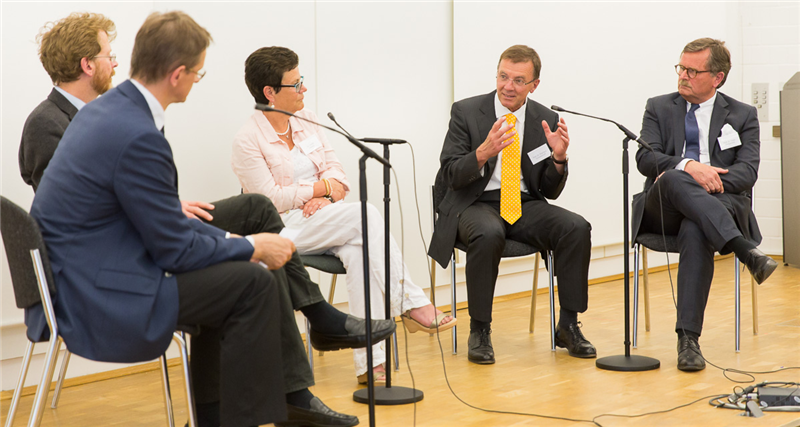 Die Referenten des Akademietags sitzen in der Dialogrunde auf dem Podium zusammen 