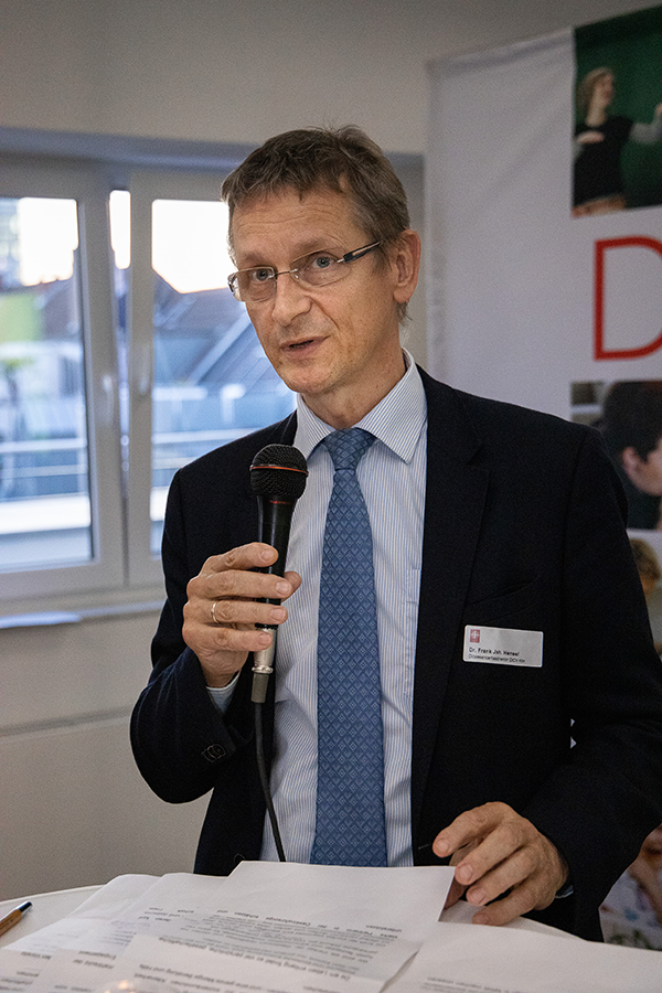 Frank Joh. Hensel steht beim Parlamentarischen Abend der Caritas in NRW am 19.09.2019 in Düsseldorf an einem Stehtisch mit einem Mirkofon in der Hand und hält seine Rede