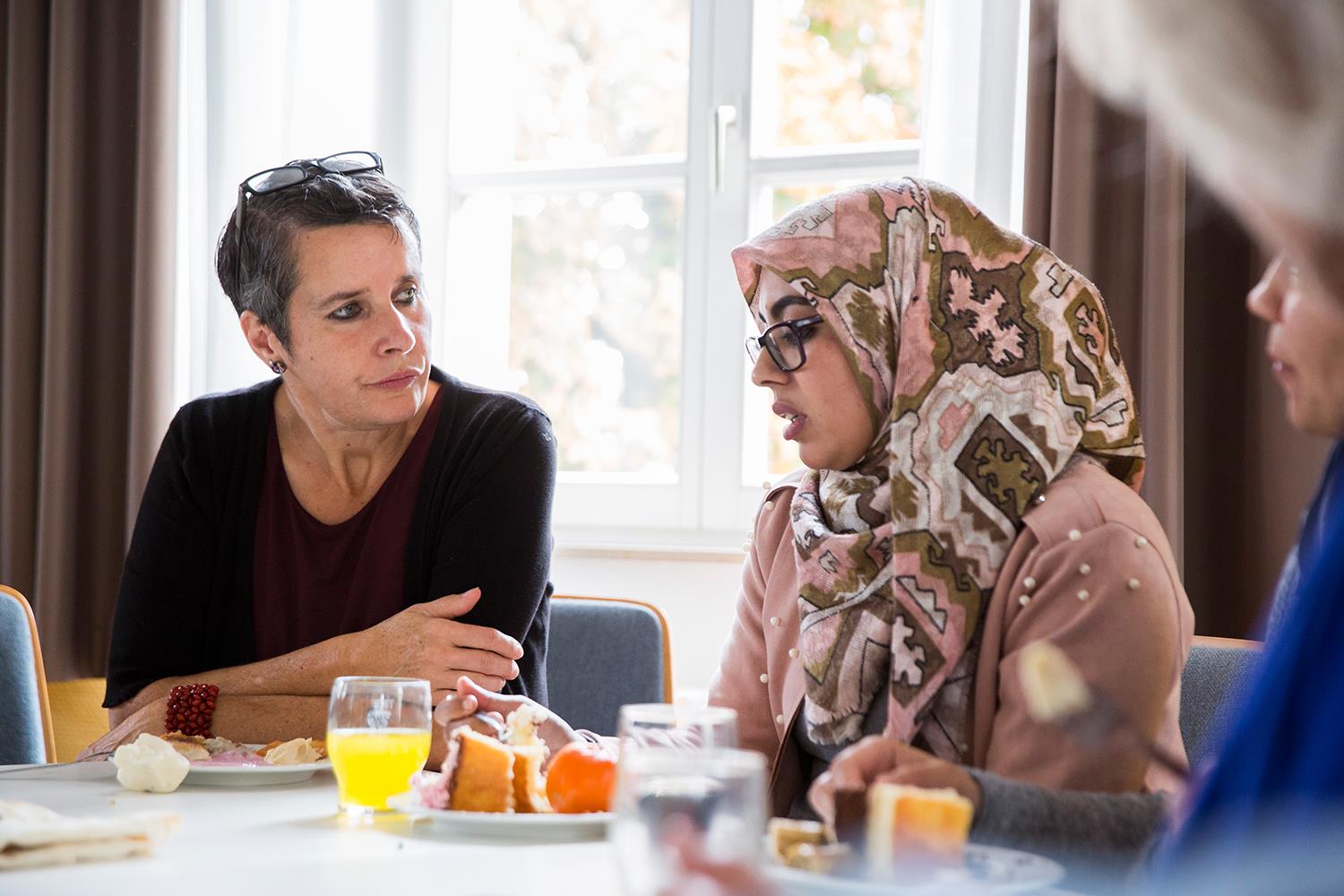 Zwei Frauen, eine mit Kopftuch, im Gespräch