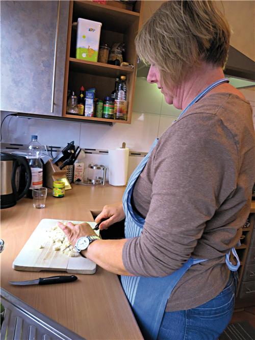 Dorfhelferin beim Zwiebelschneiden