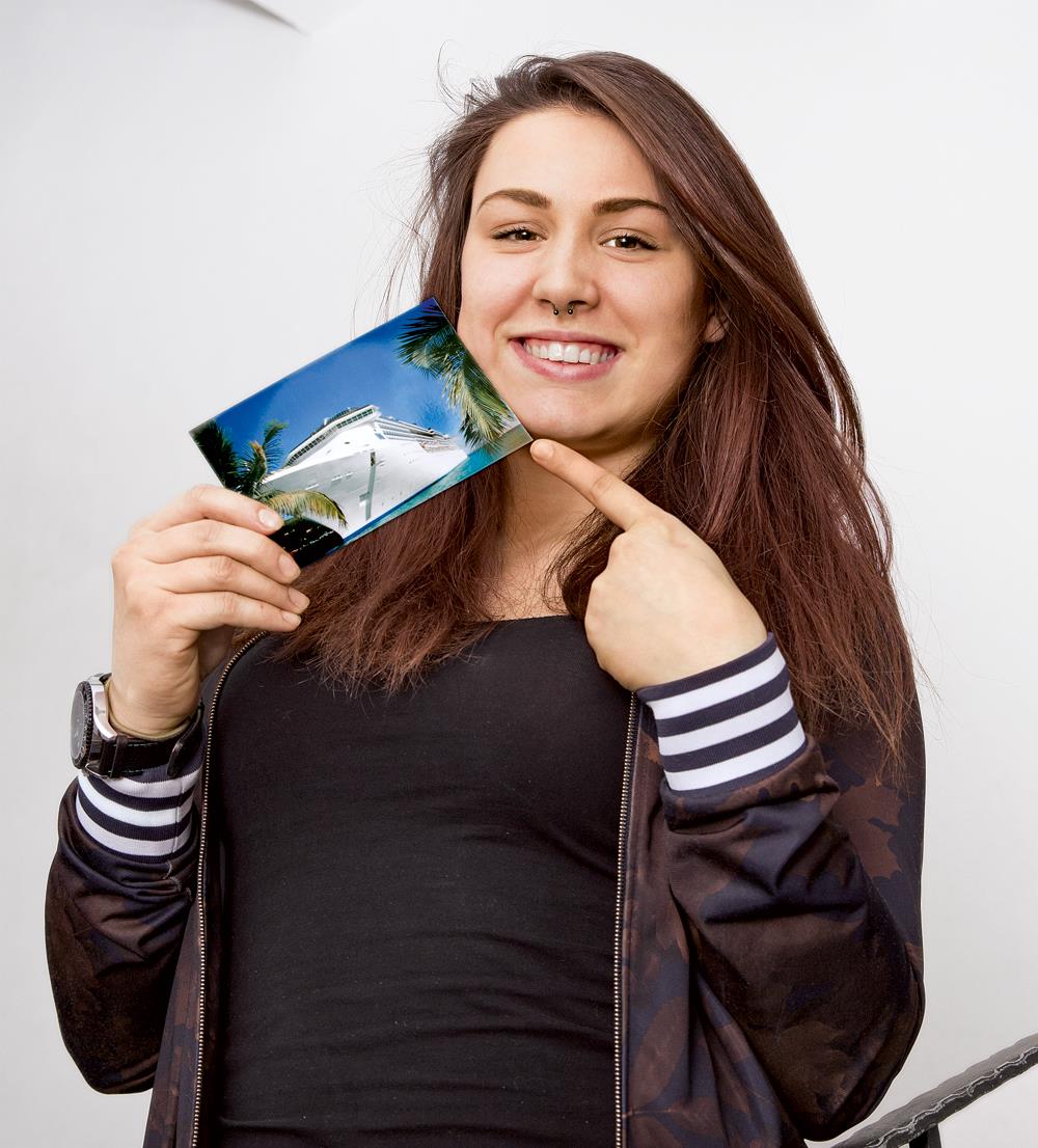 Junge Frau mit Foto eines Kreuzfahrtschiffes
