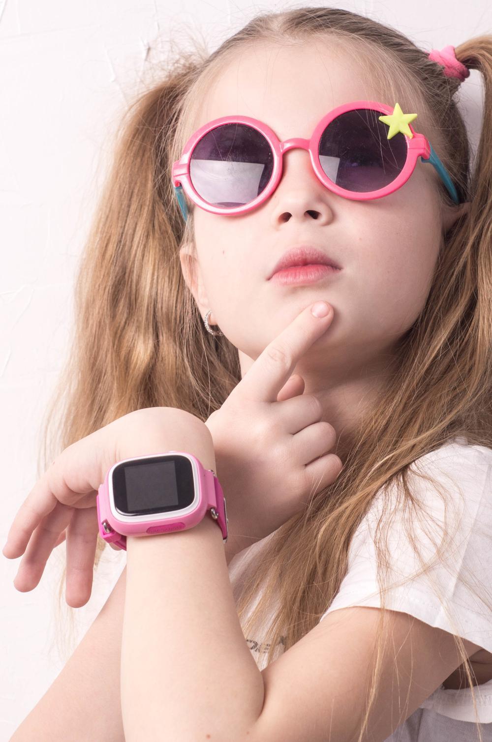 Ein zehnjähriges Mädchen mit Smartwatch schaut nachdenklich.