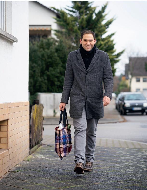 Marcel Gutting kommt mit einer Einkaufsstraße den Gehweg entlang.