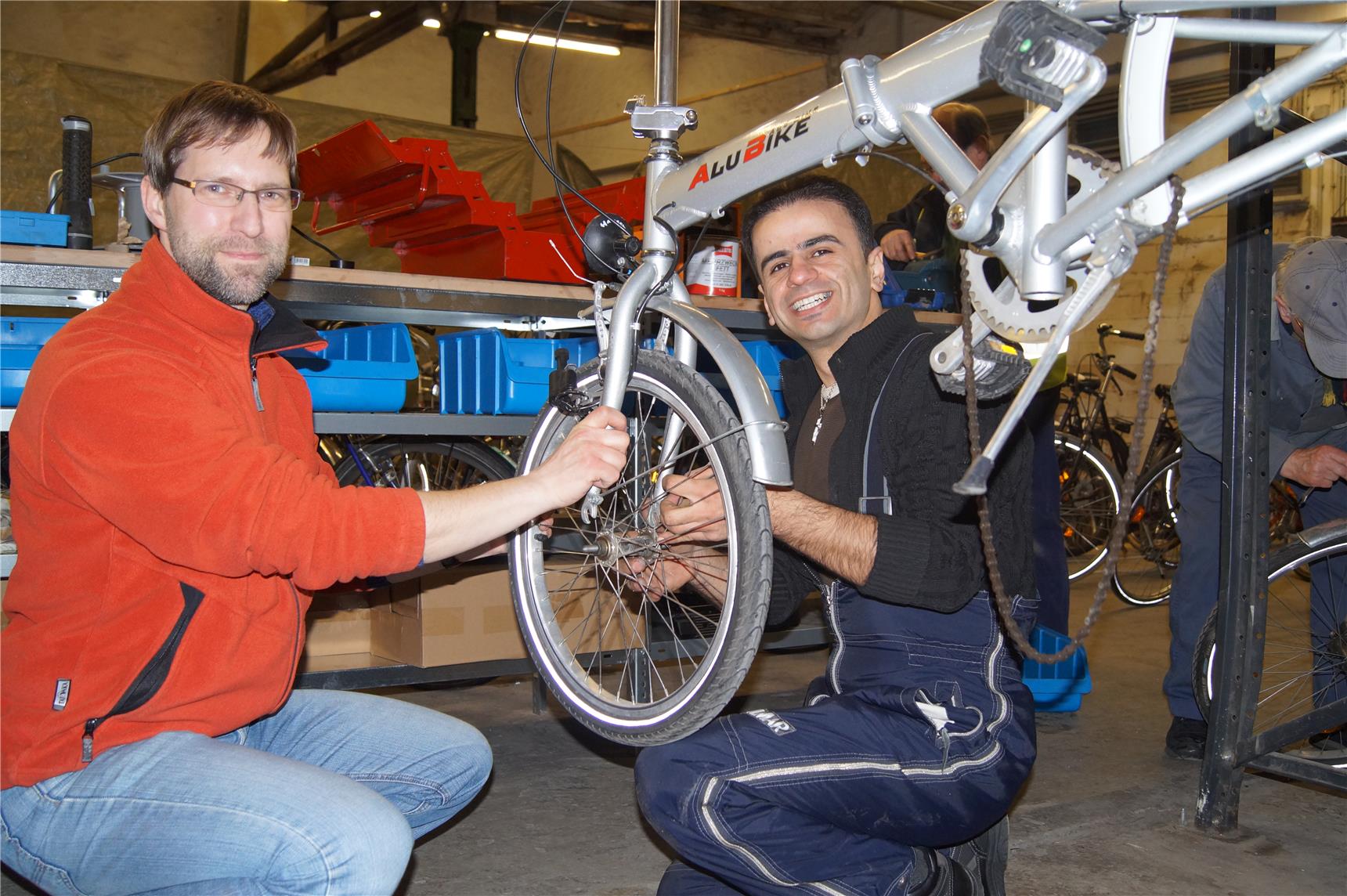 Zwei Männer reparieren zusammen ein Fahhrad