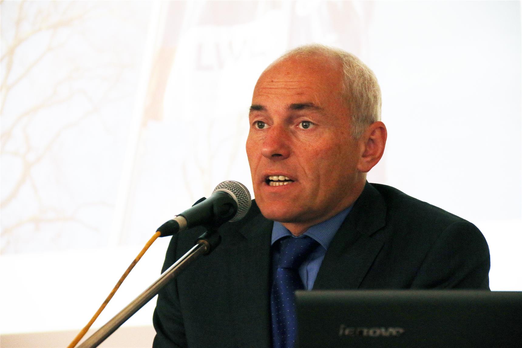 Auf dem Foto steht ein Mann am Pult.