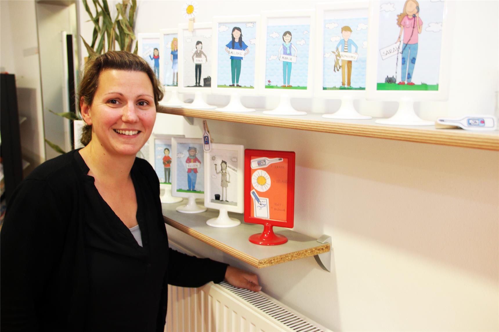 Auf dem Bild steht eine Frau vor einer Reihe Bilder