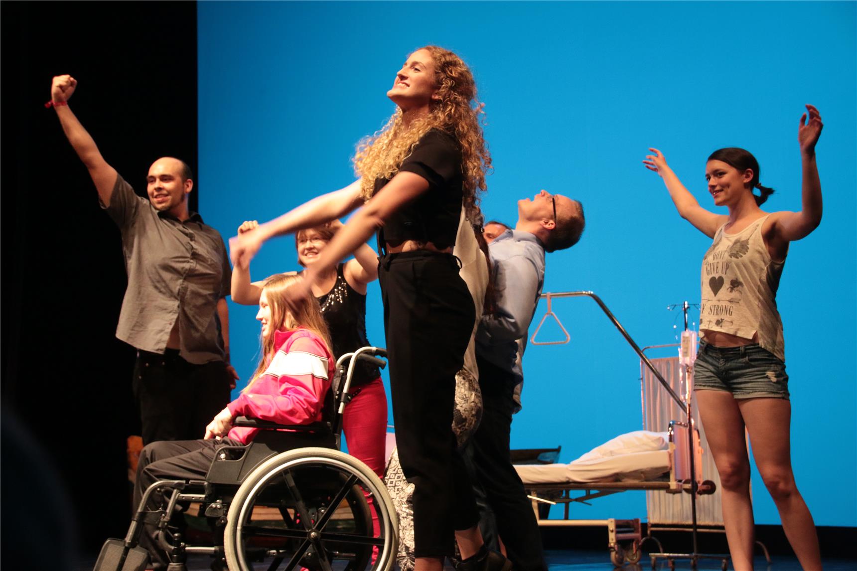 Auf dem Bild tanzen mehrere Leute, einer davon im Rollstuhl.