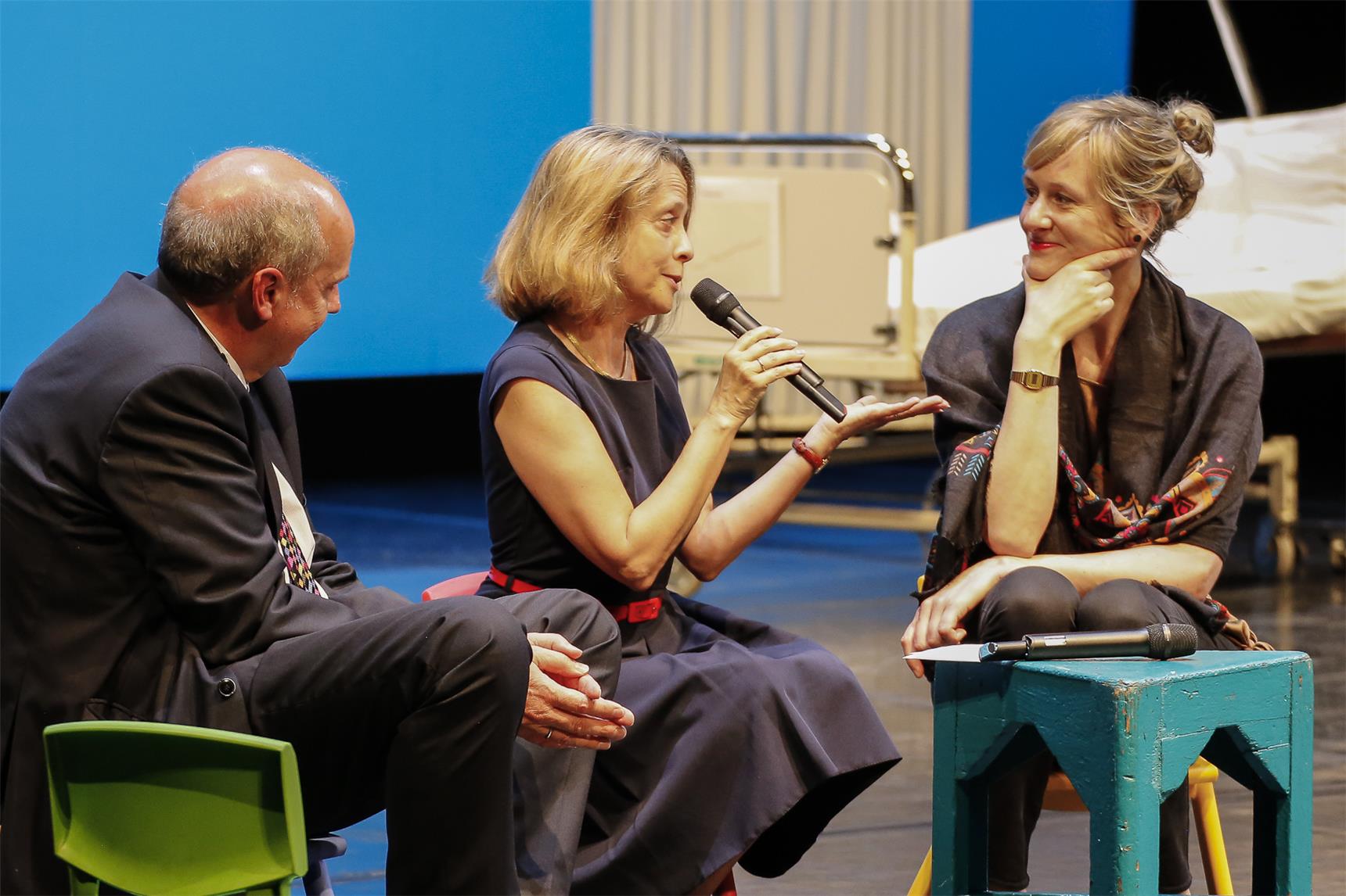 Eine Moderatorin mit Mikrofon unterhält sich mit einem Mann